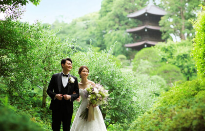 五重塔を背景に緑豊かな日本庭園で撮影する新郎新婦