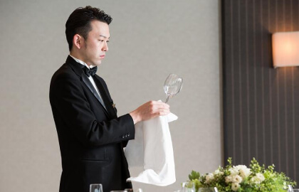 ホテルフロントでチェックイン手続きをする新郎新婦