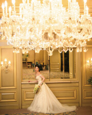 大きなシャンデリアの下でポーズをとる花嫁