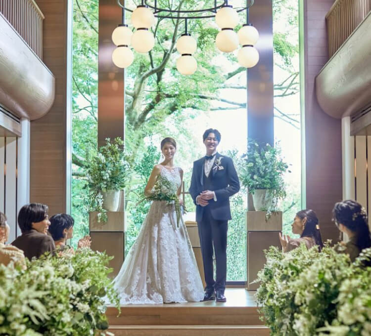 木の温もりを感じるチャペルで緑に囲まれて挙式を行う新郎新婦