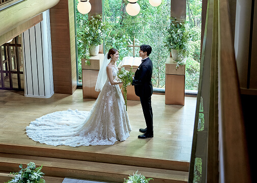 自然光の差し込むモダンなチャペルで挙式を行う新郎新婦