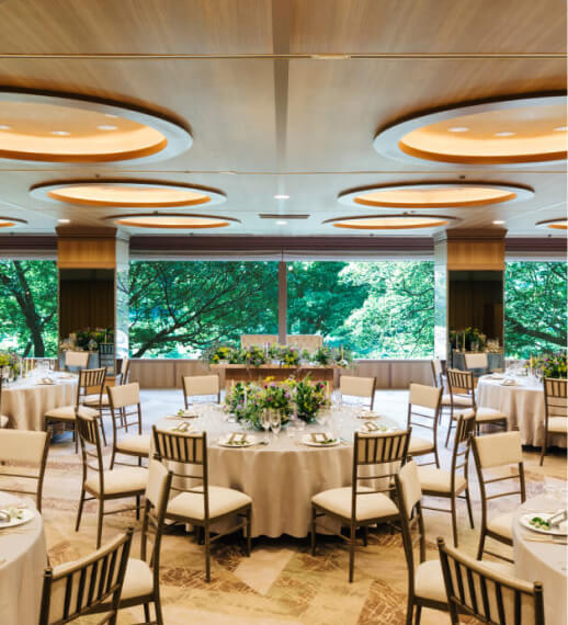 円形照明と大きな窓が特徴的なモダンな披露宴会場の内観