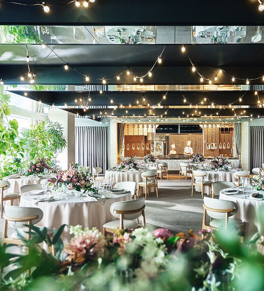 暖かい照明に包まれた披露宴会場で新郎新婦を囲む結婚式の様子